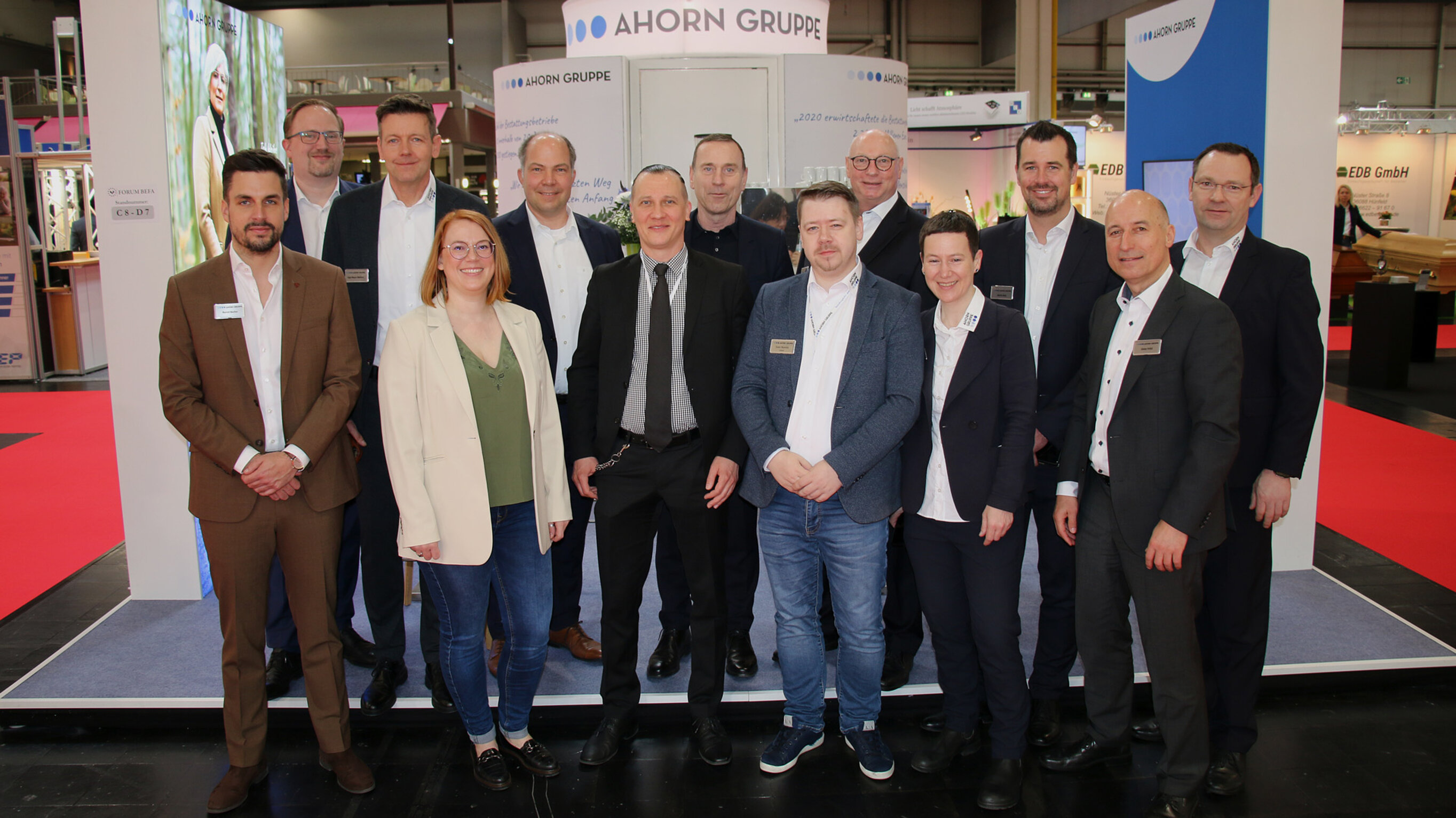 Ein Teambild mit vielen Menschen vor einem Messestand