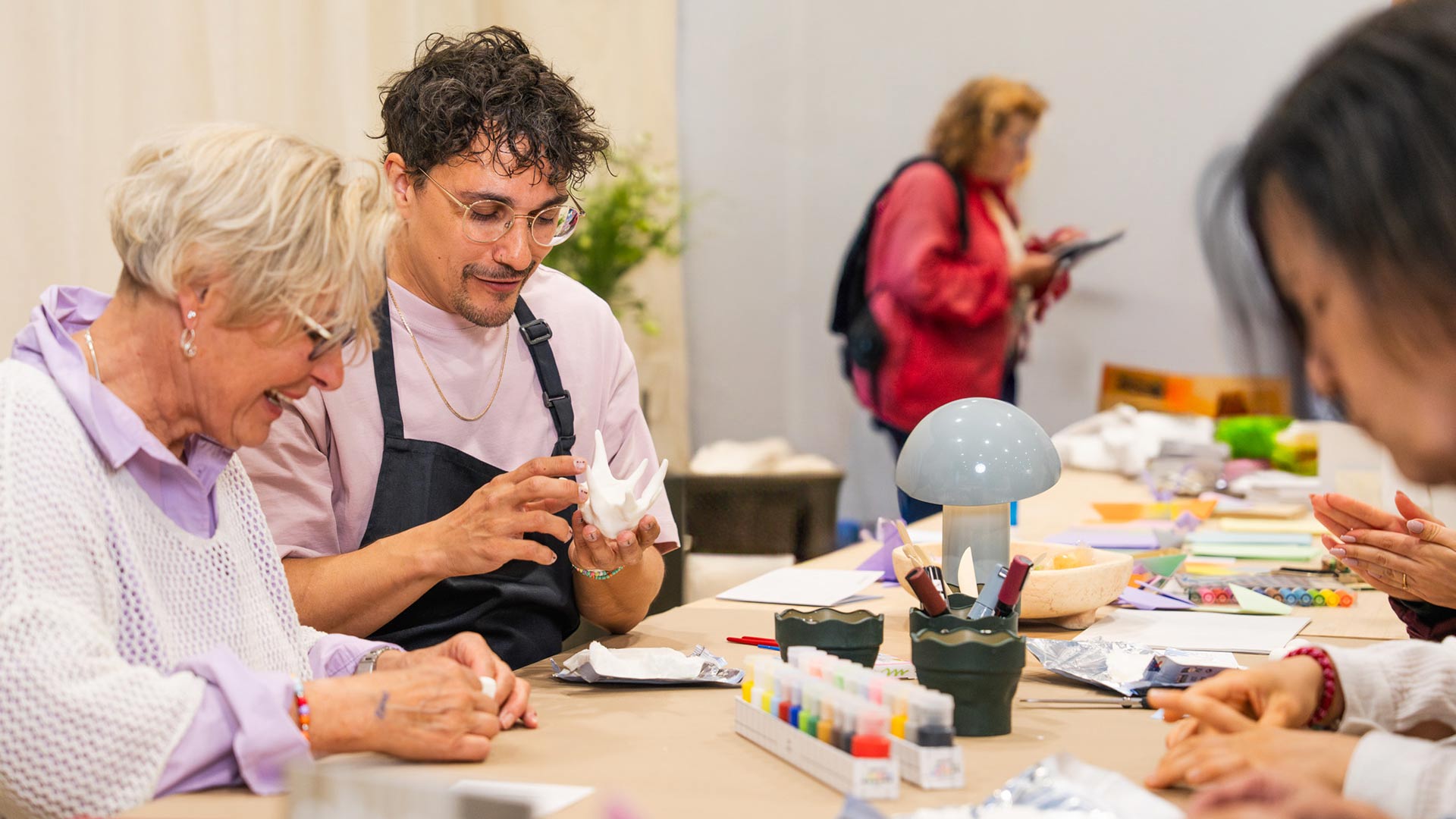 zwei Menschen an einem Tisch arbeiten mit Knete